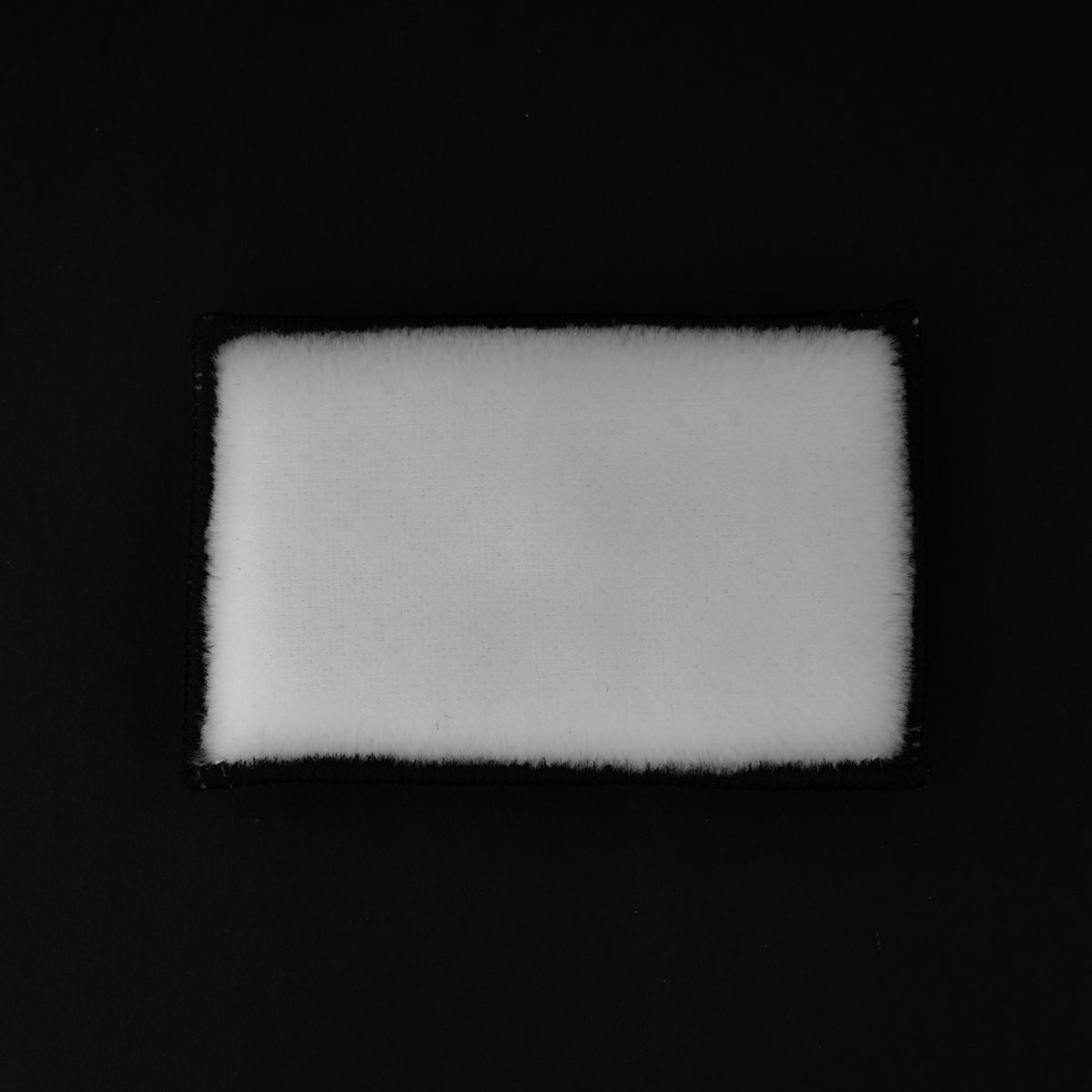 Rectangular white foam block on a black background