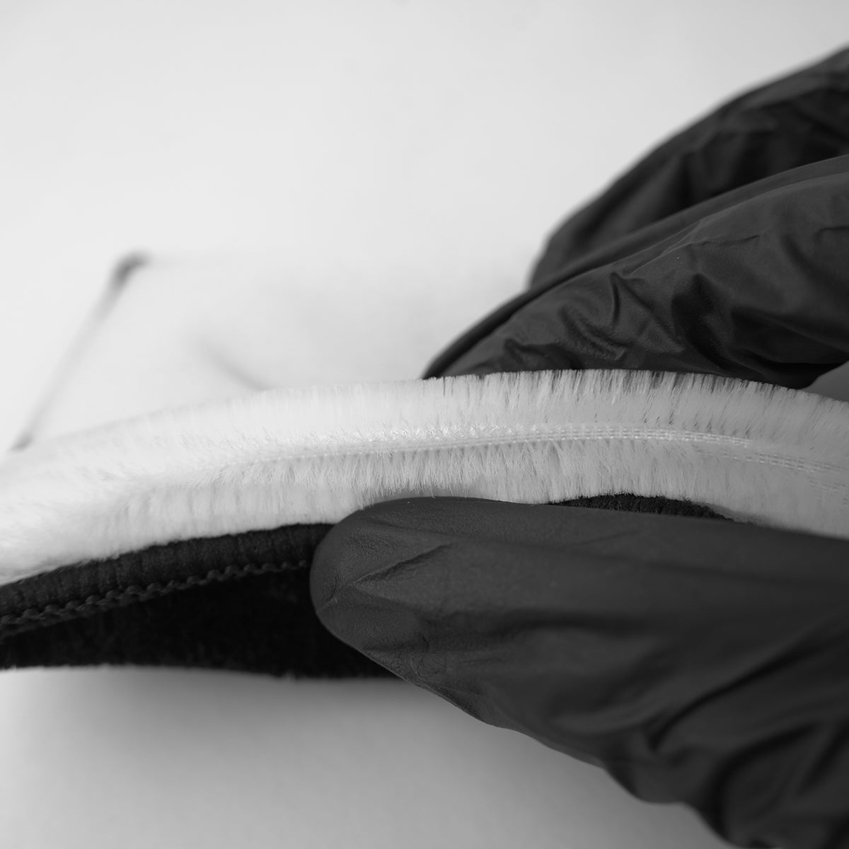 Close-up of a black jacket zipper on a white background