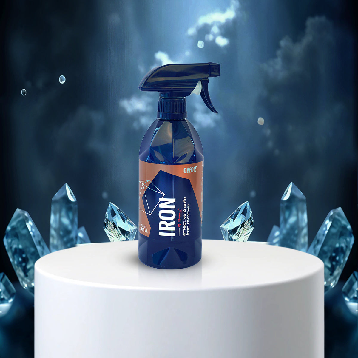 Blue spray bottle labeled 'IRON' on a white pedestal with crystal-like shapes in the background
