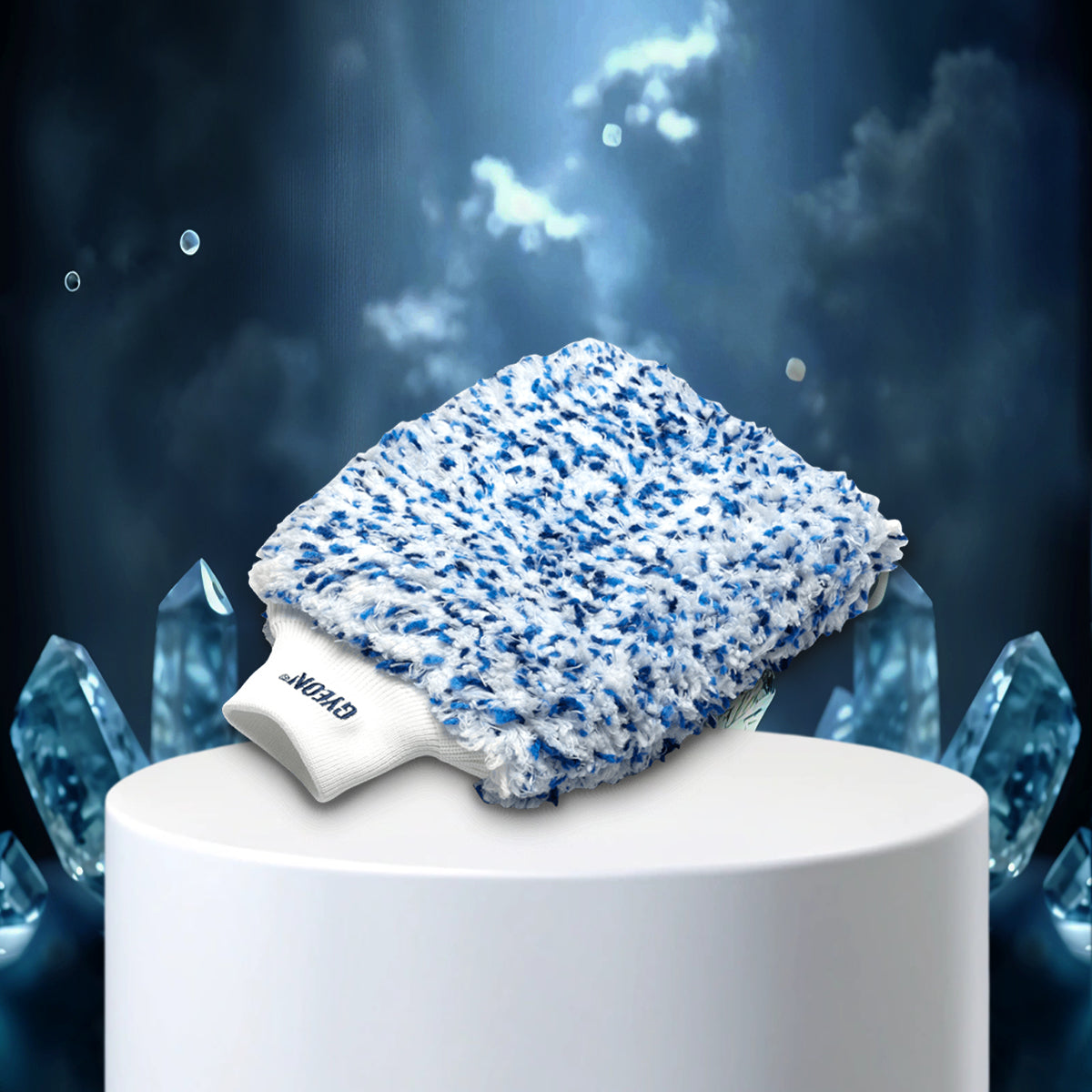 Blue and white textured cleaning pad on a white stand with a dark, crystal-like background