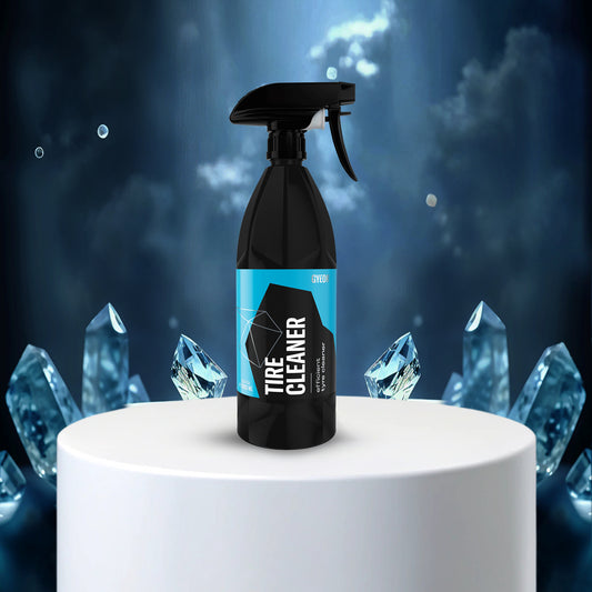 Gyeon Q2M Tire Cleanercleaner spray bottle with blue label on a white pedestal against a dark background with crystal-like shapes.