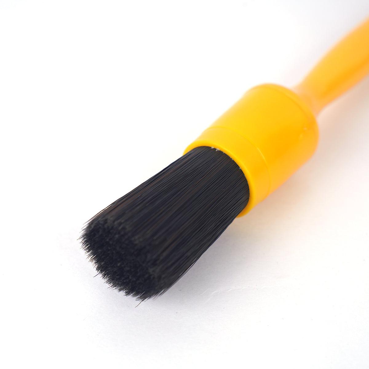 Yellow brush with black bristles on a white background