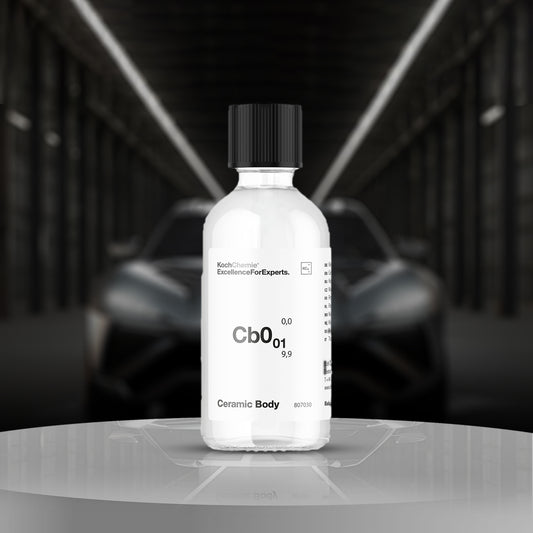 Bottle of Ceramic Body product on a reflective surface with a blurred car in the background