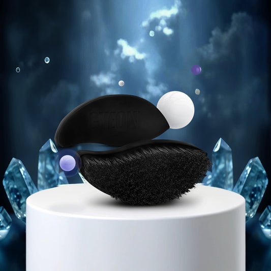 Gyeon Q2M Tire Brush Black abalone shell with a white pearl on a white pedestal against a mystical background with crystals and light effects.