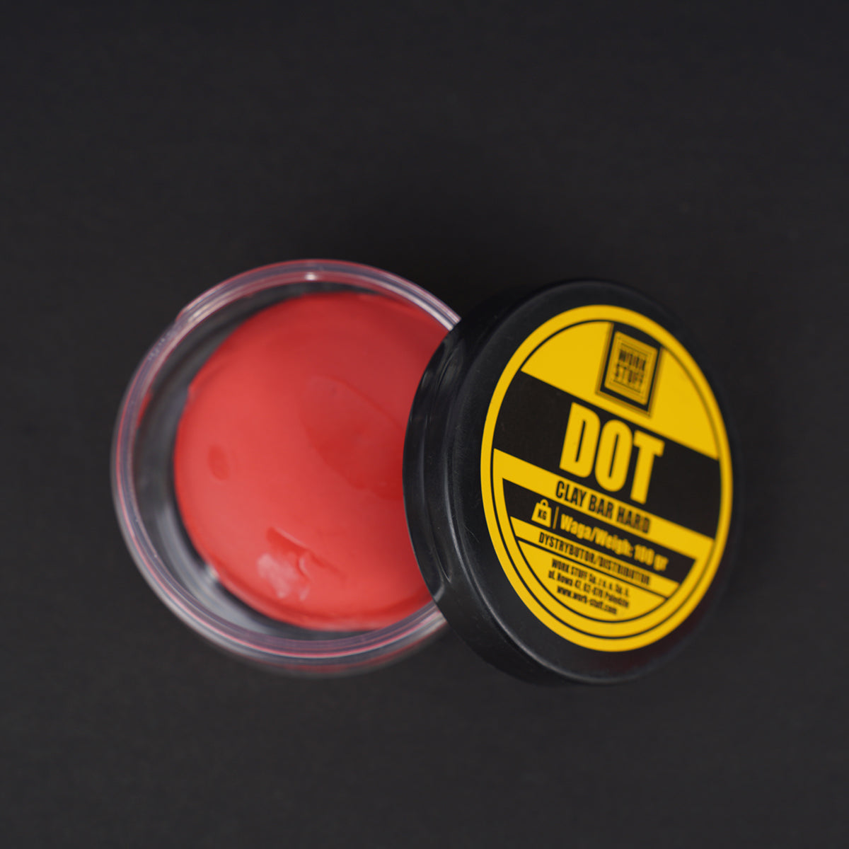 Red clay bar in a container with a yellow label on a black background