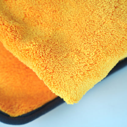 Close-up of two orange microfiber cloths on a blue background