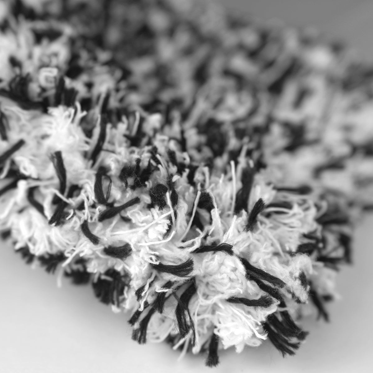 Close-up of a black and white pom-pom on a blurred background